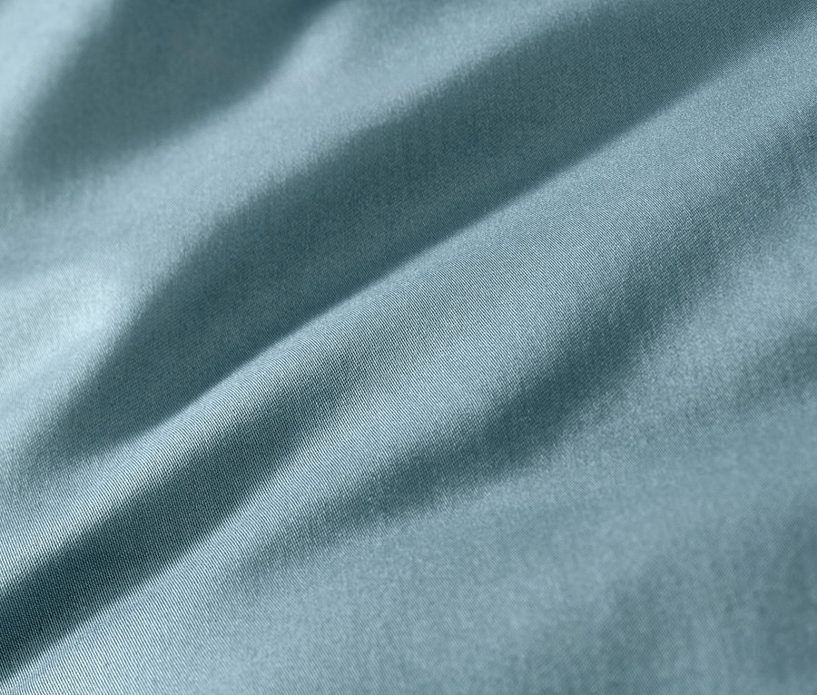 Gros plan d'une parure de lit bleu en satin de coton.