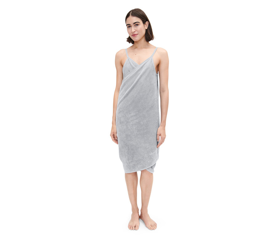 Une femme debout porte une robe-serviette grise.
