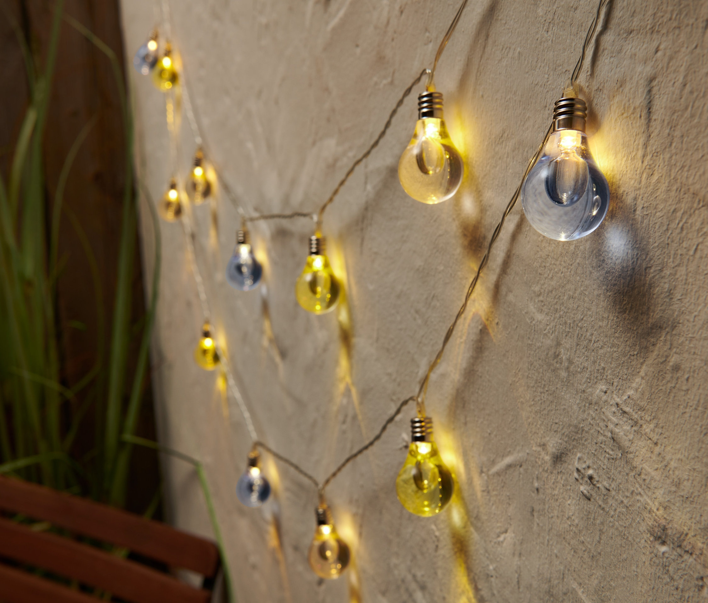 Guirlande lumineuse à LED avec des ampoules bleues et jaunes sur un mur.