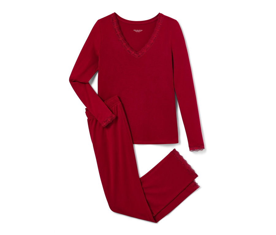 Un pyjama rouge avec des garnitures en dentelle est posé, plié.