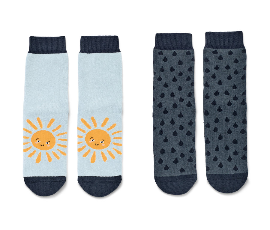 Deux paires de chaussettes antidérapantes bleues pour tout-petits avec motif soleil et pluie.
