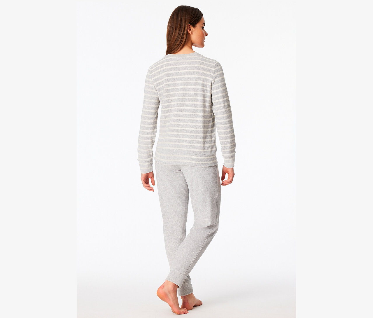 Une femme, vue de dos, porte un T-shirt à manches longues gris rayé et un pantalon de survêtement gris.