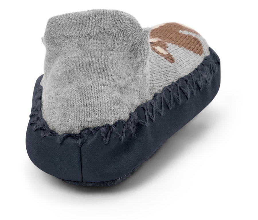 Gros plan d'un chausson gris pour bébé avec un motif marron et une semelle bleu foncé.