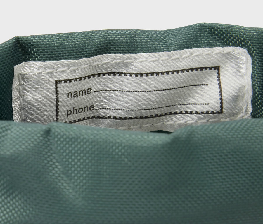 Détail de bottes en caoutchouc pour enfants avec un imprimé animalier intégral et une étiquette pour le nom et le téléphone.