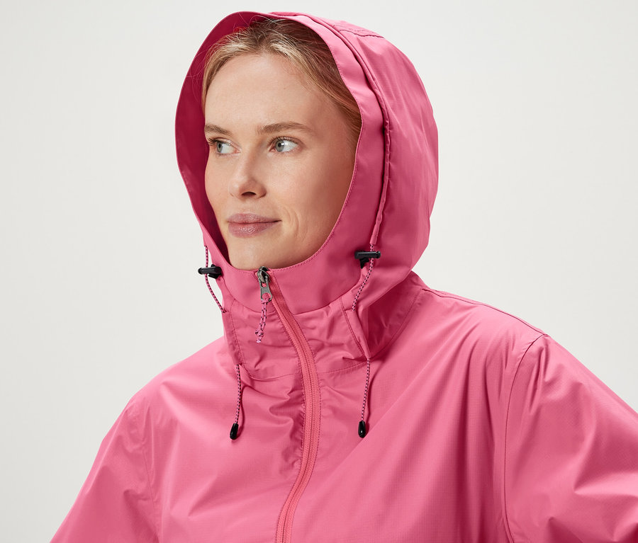 Une femme porte une veste rose à capuche.