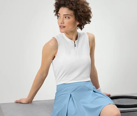 Femme assise portant un top fonctionnel blanc.