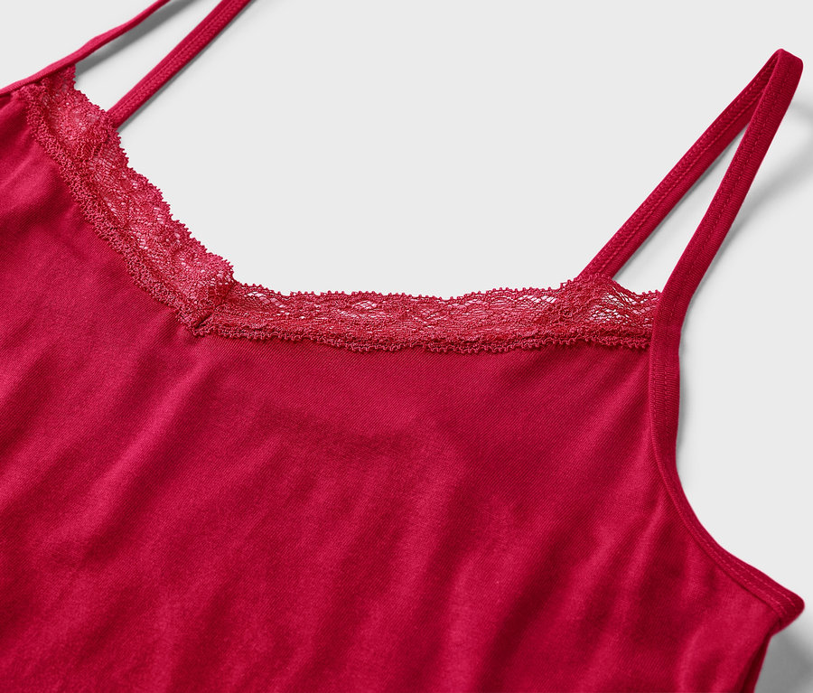 Vue détaillée d'un débardeur rouge avec de la dentelle autour de l'encolure.