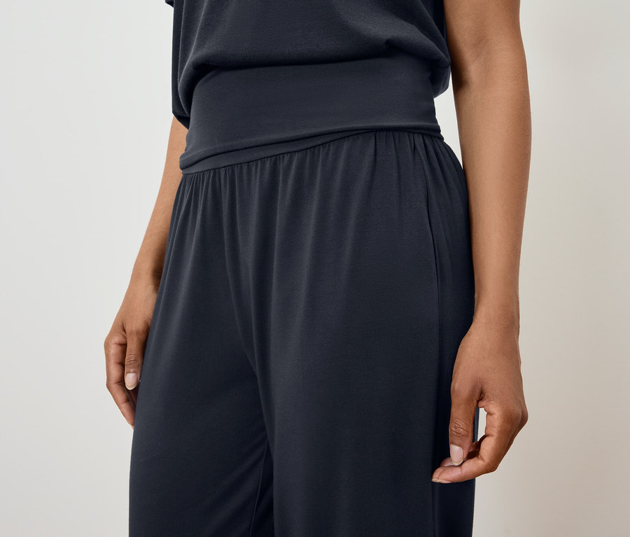 Une femme porte un pyjama noir.