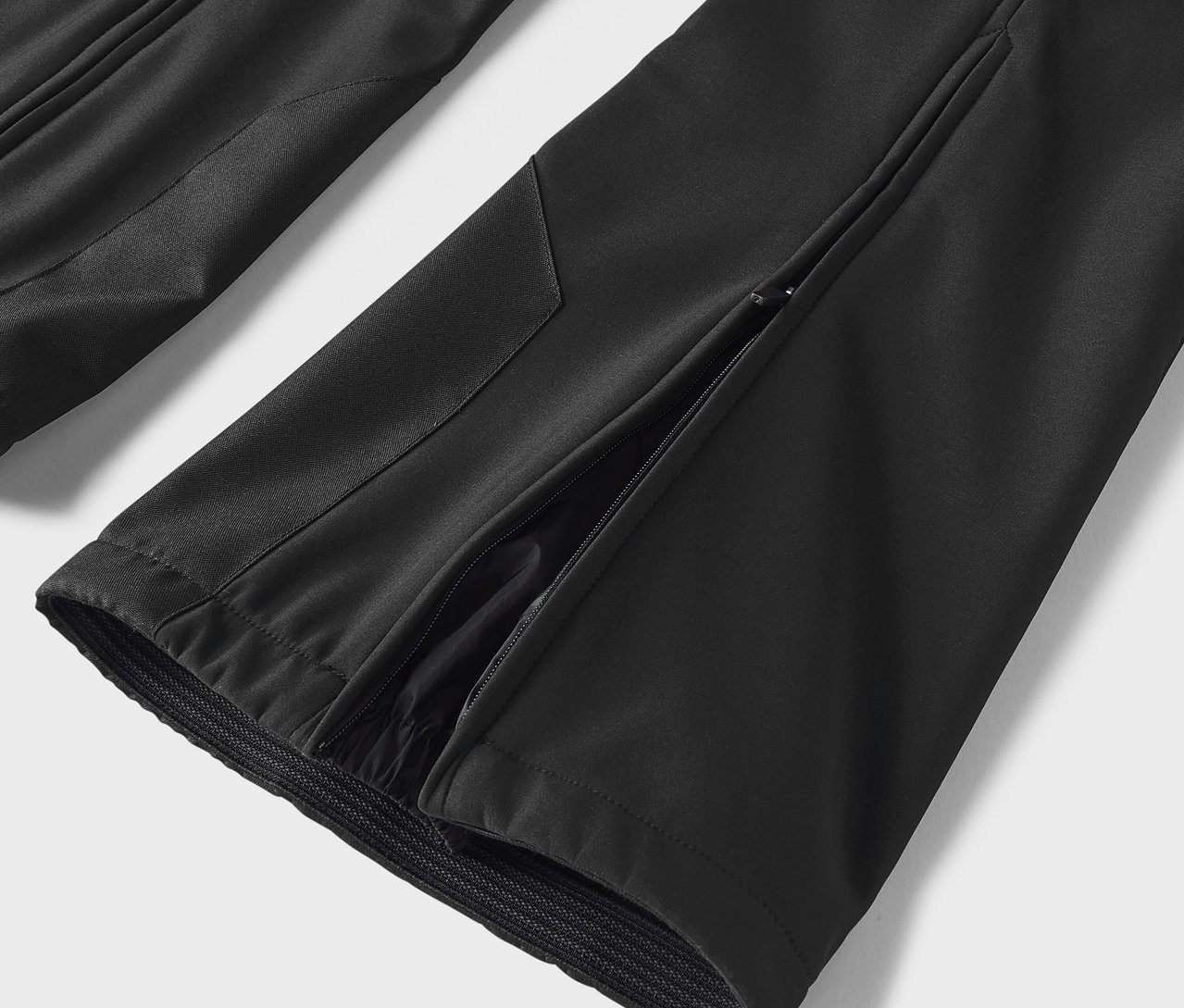 Détail d'un pantalon noir avec une fente sur le côté.