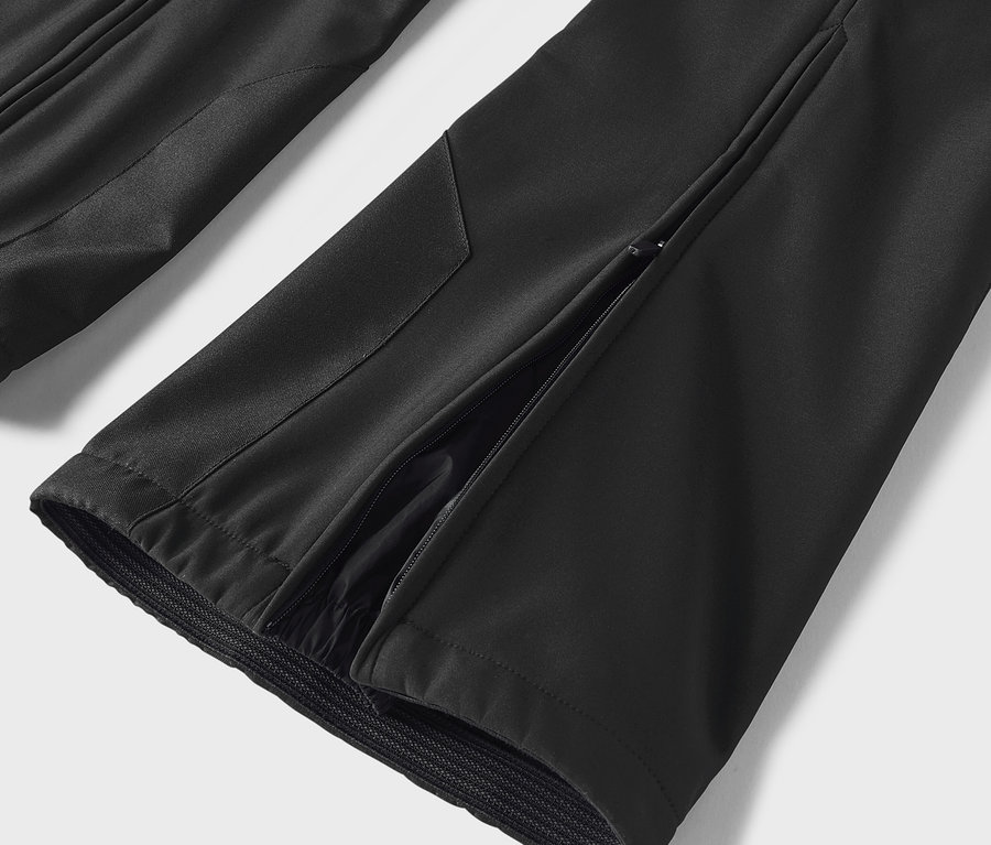 Détail d'un pantalon noir avec une fente sur le côté.