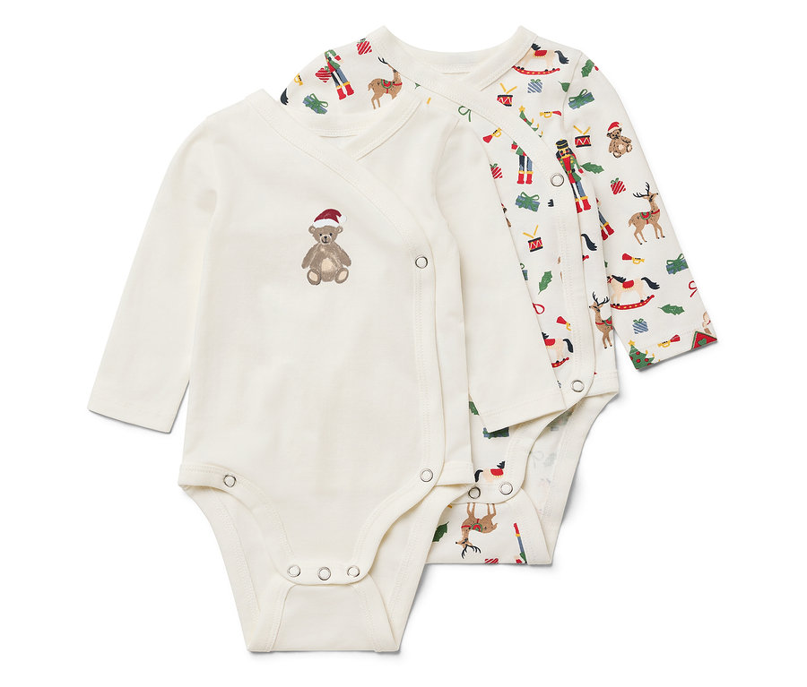 Deux bodies blancs à manches longues. L'un a un ours en peluche marron avec un chapeau rouge et l'autre un motif de Noël.