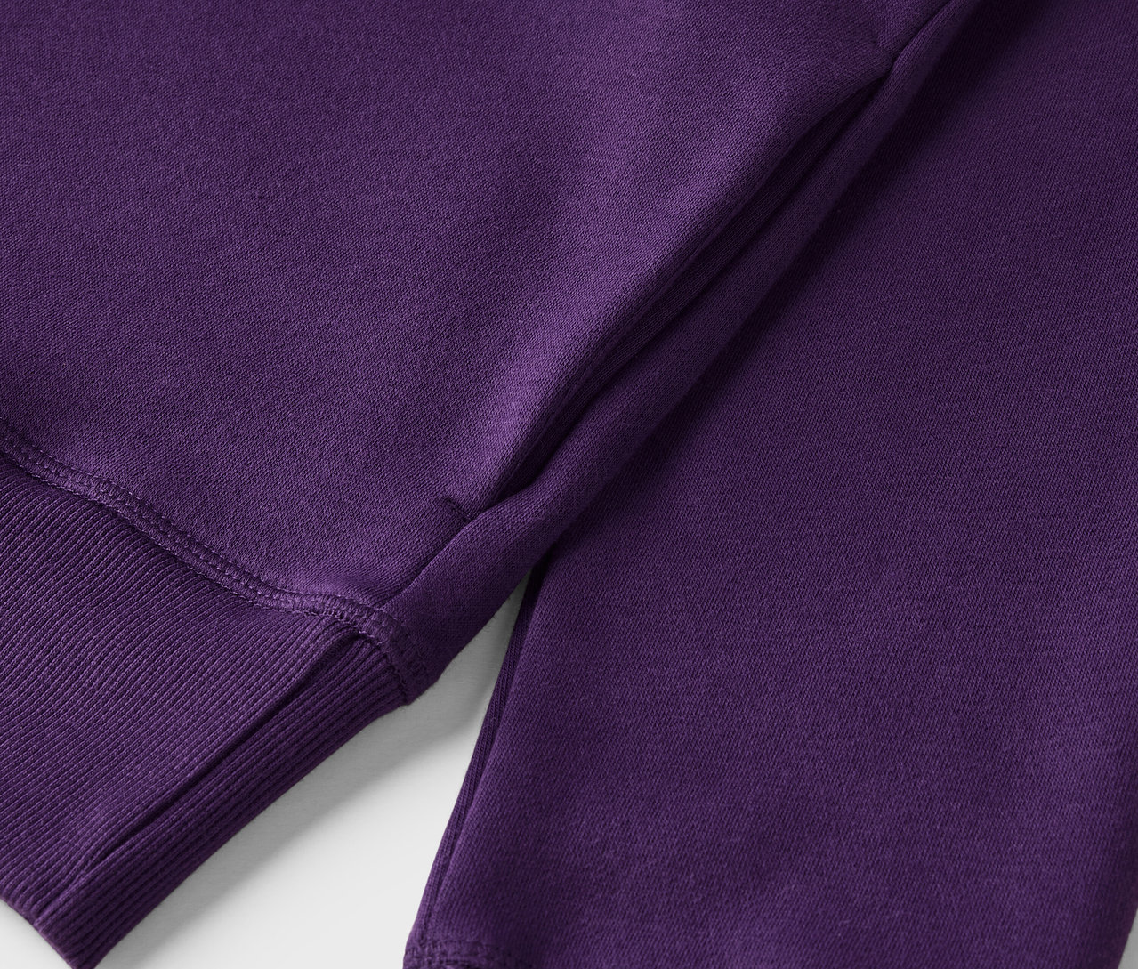 Gros plan sur un sweat-shirt violet avec un ourlet côtelé.