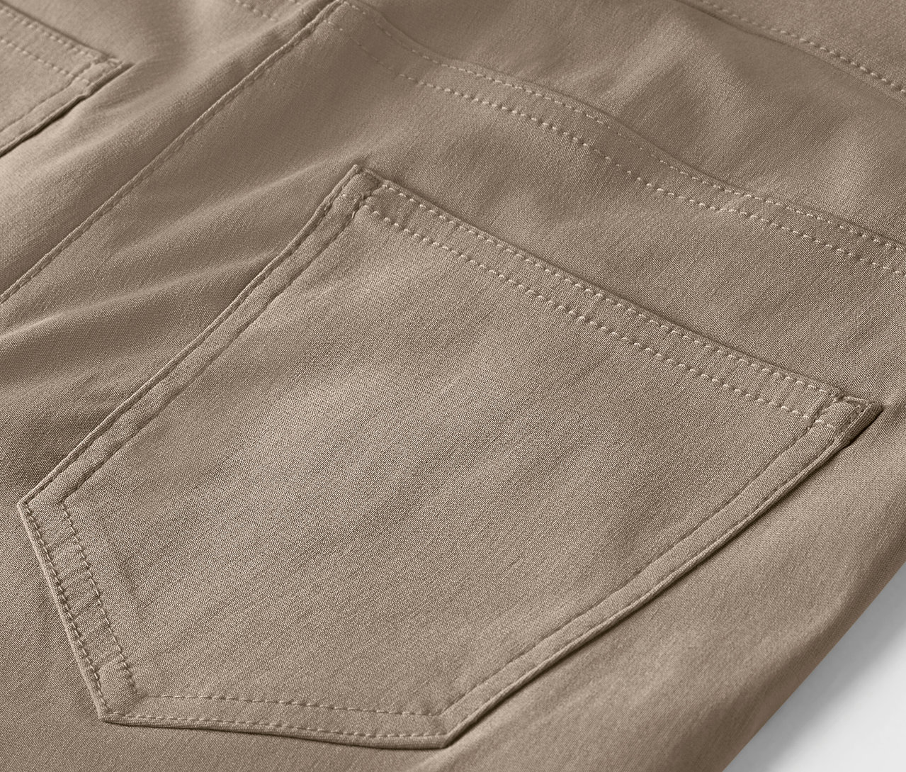 Détail d'un pantalon marron avec une poche.