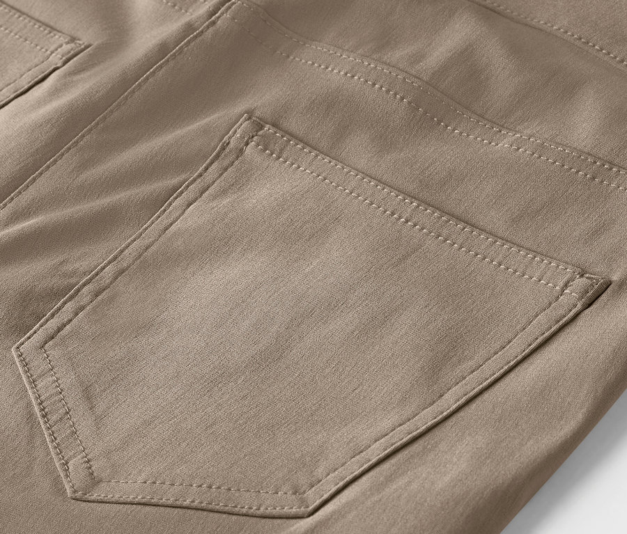 Détail d'un pantalon marron avec une poche.