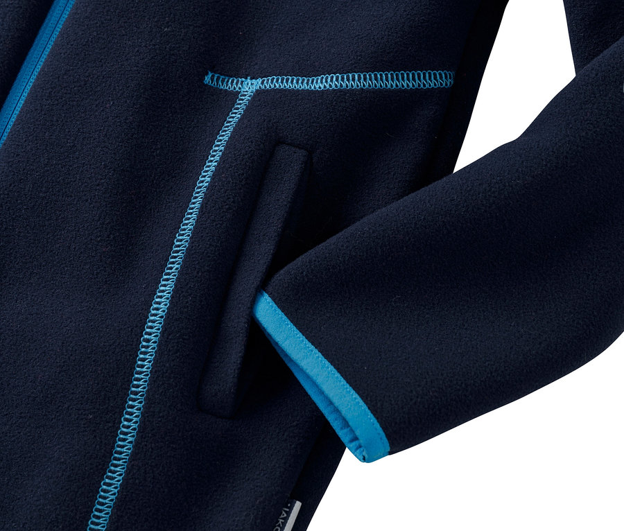 Détail d'une veste en polaire bleu marine avec des finitions bleu azur sur la poche et la manche.