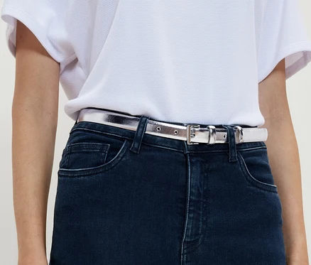 Une femme porte un jean et une ceinture.