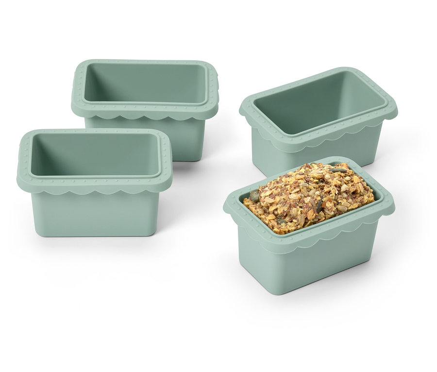 Quatre moules à glaçons en silicone verts, un rempli de glaçons.