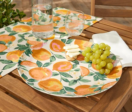 Plat de service avec fruits, fromage et raisins sur une table en bois.