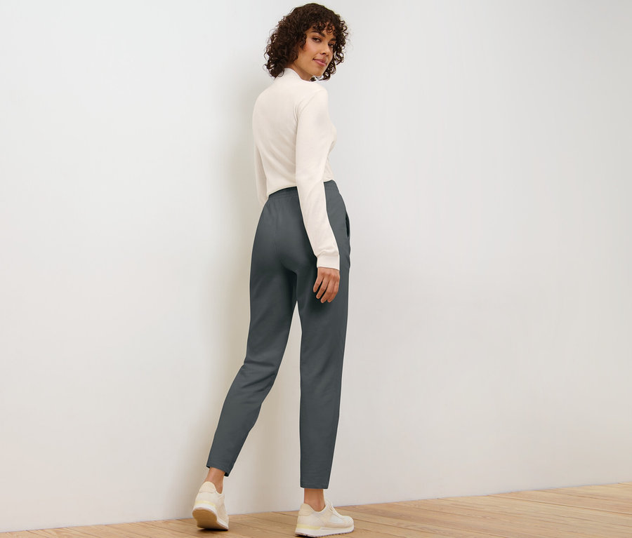 Femme regardant par-dessus son épaule et posant en pantalon de jogging.