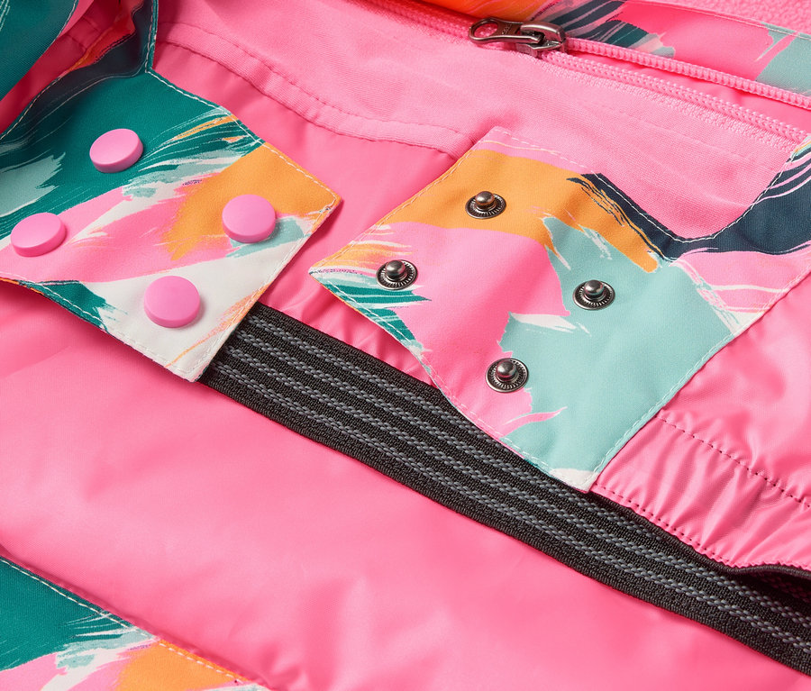 Détail d'une veste avec doublure rose, motifs colorés et boutons-pression.