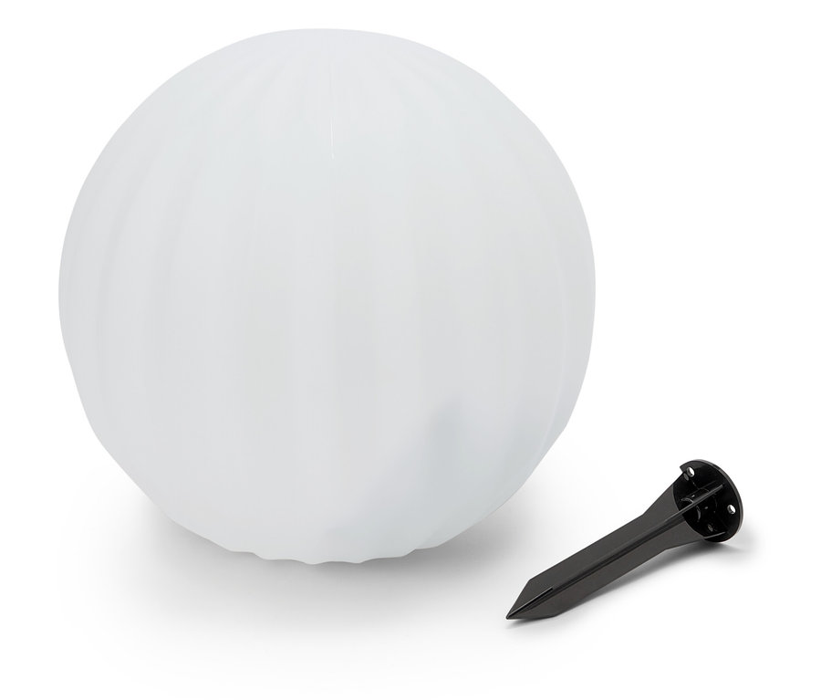 Une sphère blanche repose à côté d'un piquet de terre noir.