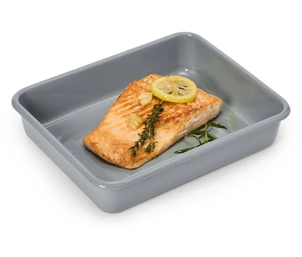 Un filet de saumon avec du citron et des herbes dans un plat à gratin gris.