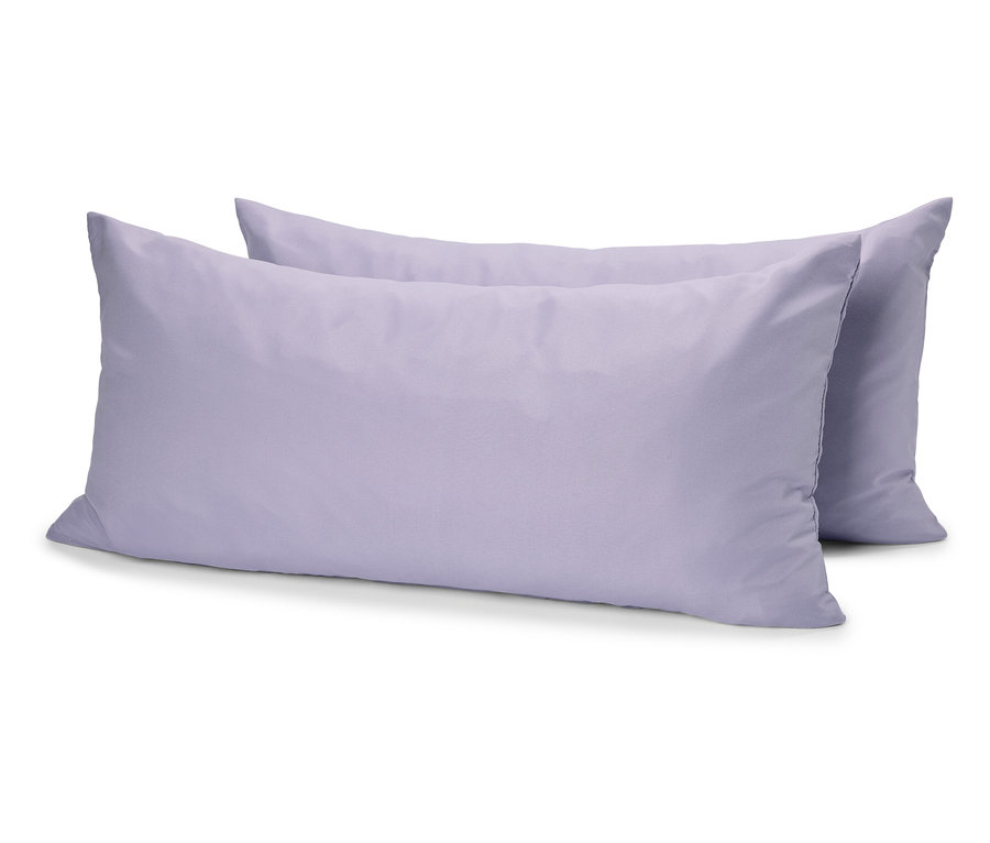 Deux oreillers violets sont posés l'un sur l'autre sur une surface blanche.