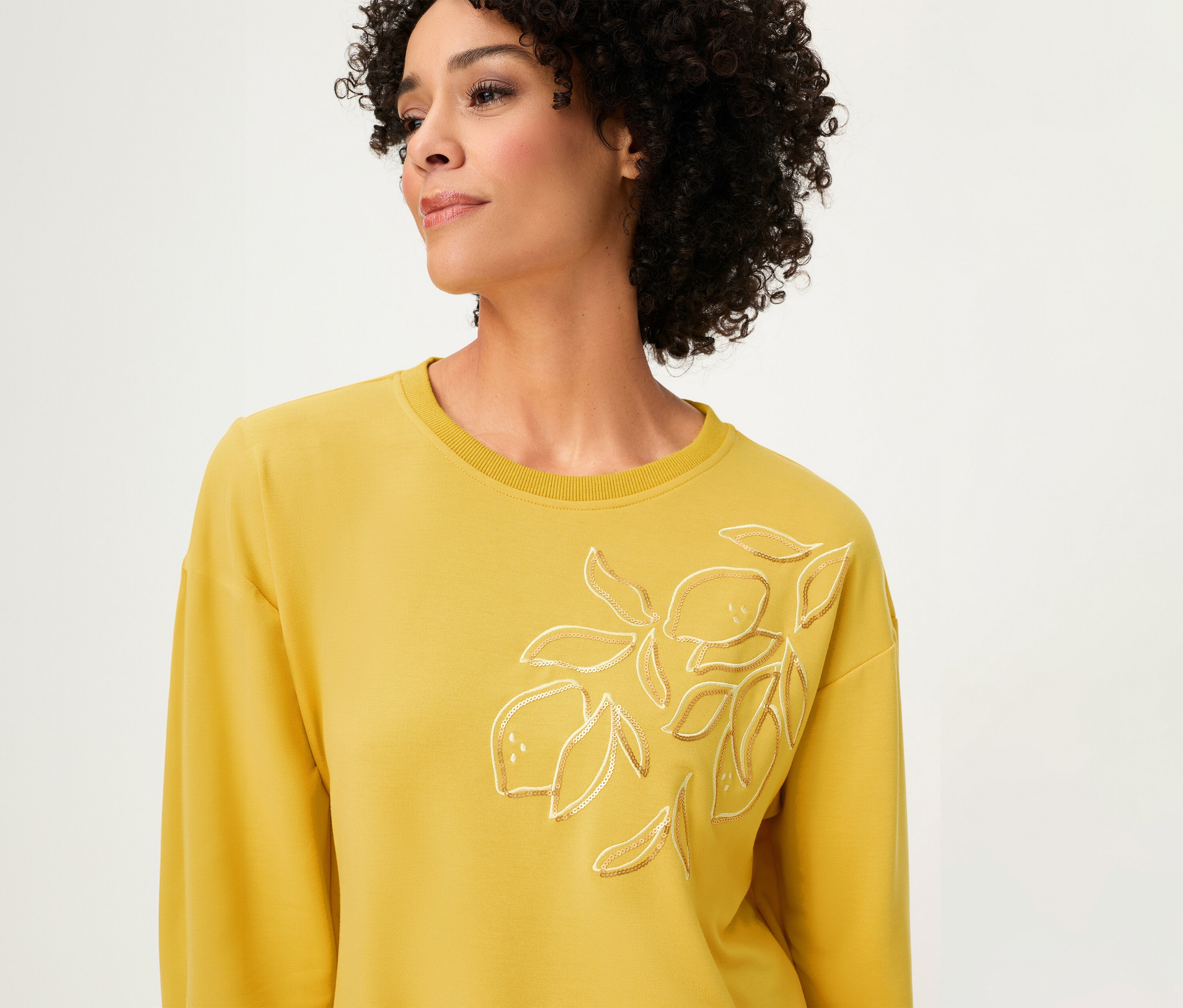 Femme portant un sweat-shirt Olsen manches longues jaune avec motif citron.