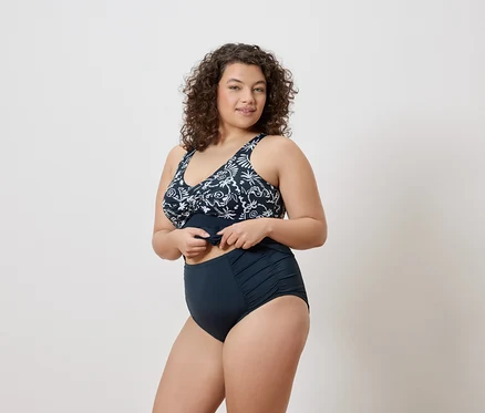 Femme portant un maillot de bain bleu marine à motif floral.
