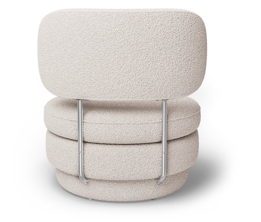 Un fauteuil crème avec trois coussins ronds et un coussin de dossier soutenus par un cadre métallique argenté.
