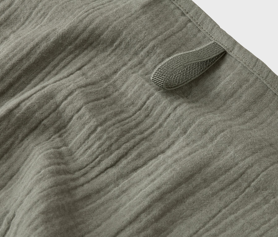 Gros plan d'un tissu mousseline vert olive avec une boucle.