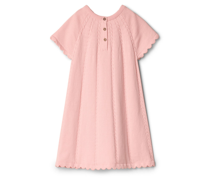 Une robe en tricot rose à manches courtes et ourlets ondulés repose sur un fond blanc.