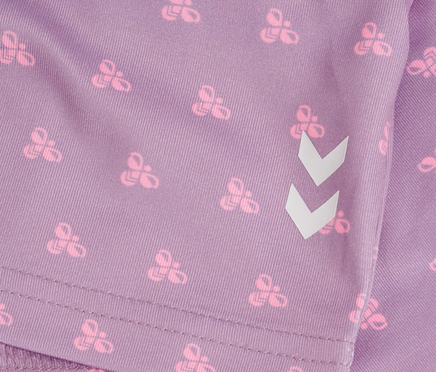 Gros plan d'un tissu violet avec un motif de nœuds roses et un angle blanc.