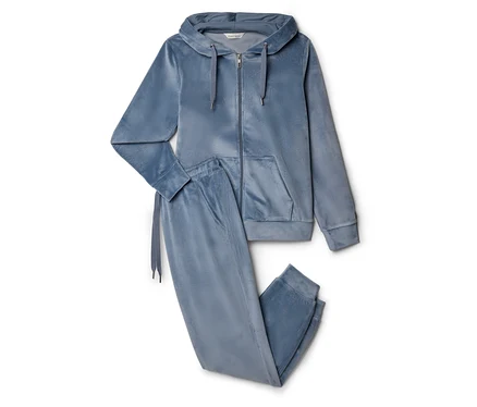 Un ensemble de survêtement en velours bleu comprenant un sweat à capuche zippé avec cordon de serrage et un pantalon de jogging posé sur un fond blanc.