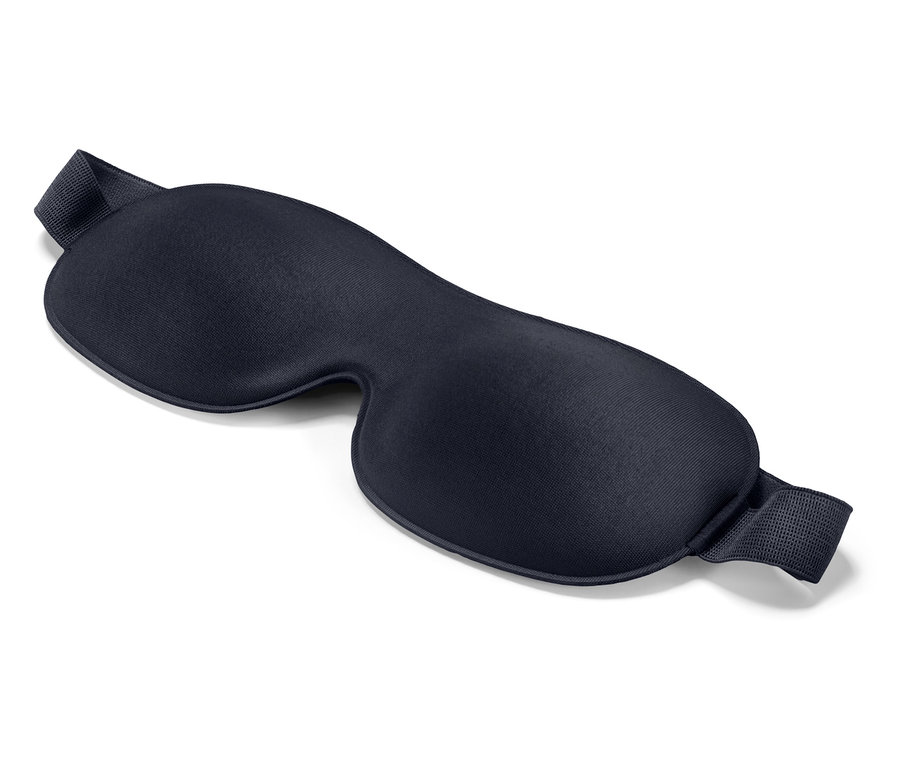 Un masque de sommeil bleu marine repose sur un fond blanc.