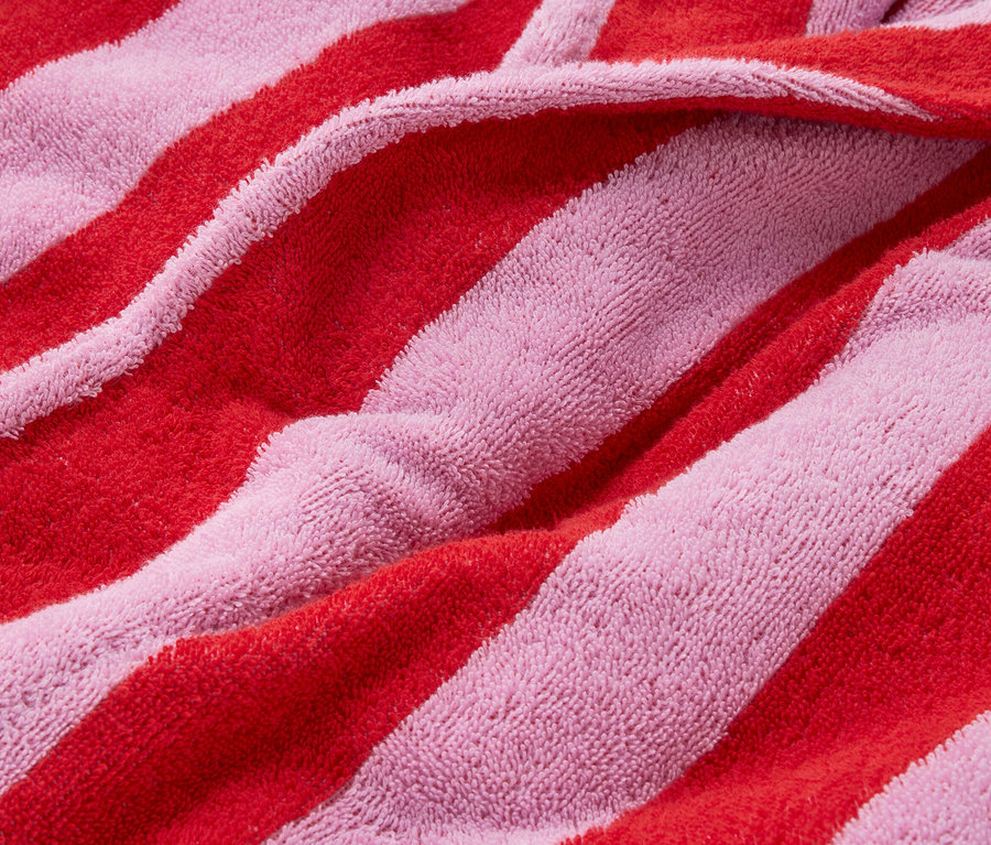 Gros plan d'un tissu éponge rayé rose et rouge.