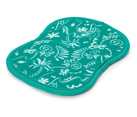 Un dessous de verre turquoise avec un motif floral blanc repose sur un fond blanc.
