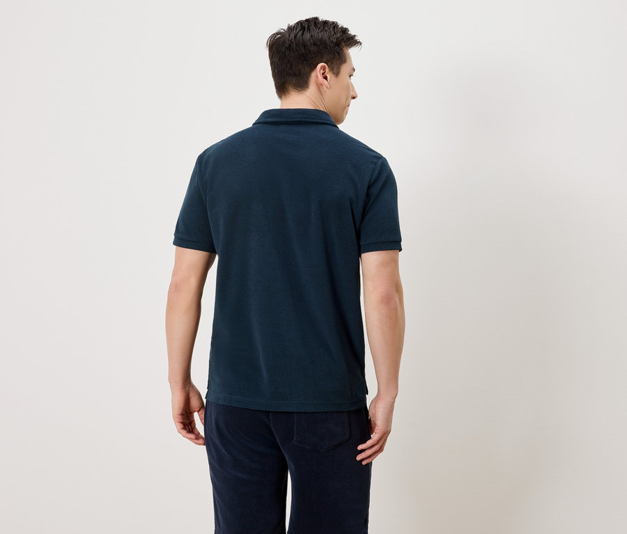 Vue arrière d'un homme portant un polo bleu marine et un pantalon bleu marine.