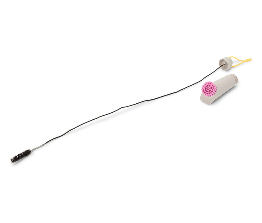 Une brosse de nettoyage avec une longue tige noire fine et un manche gris avec une tête de brosse rose repose sur un fond blanc.