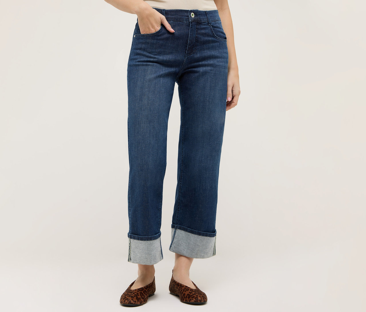 Une personne porte un jean bleu foncé Angels Denim «	Laia Turn-Up	», Wide Leg, avec des ourlets retroussés et des ballerines à imprimé animal.