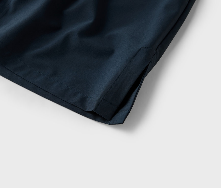 Gros plan de la poche d'un short bleu marine sur fond blanc.