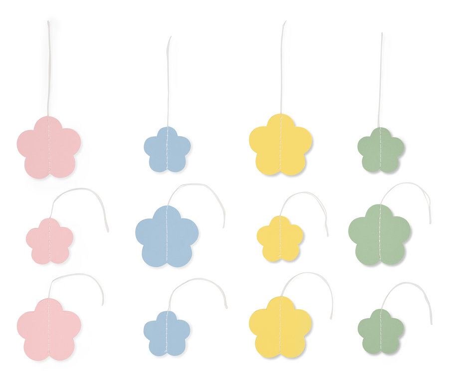 Des pendentifs multicolores en forme de fleurs suspendus à des cordes sur un fond blanc.