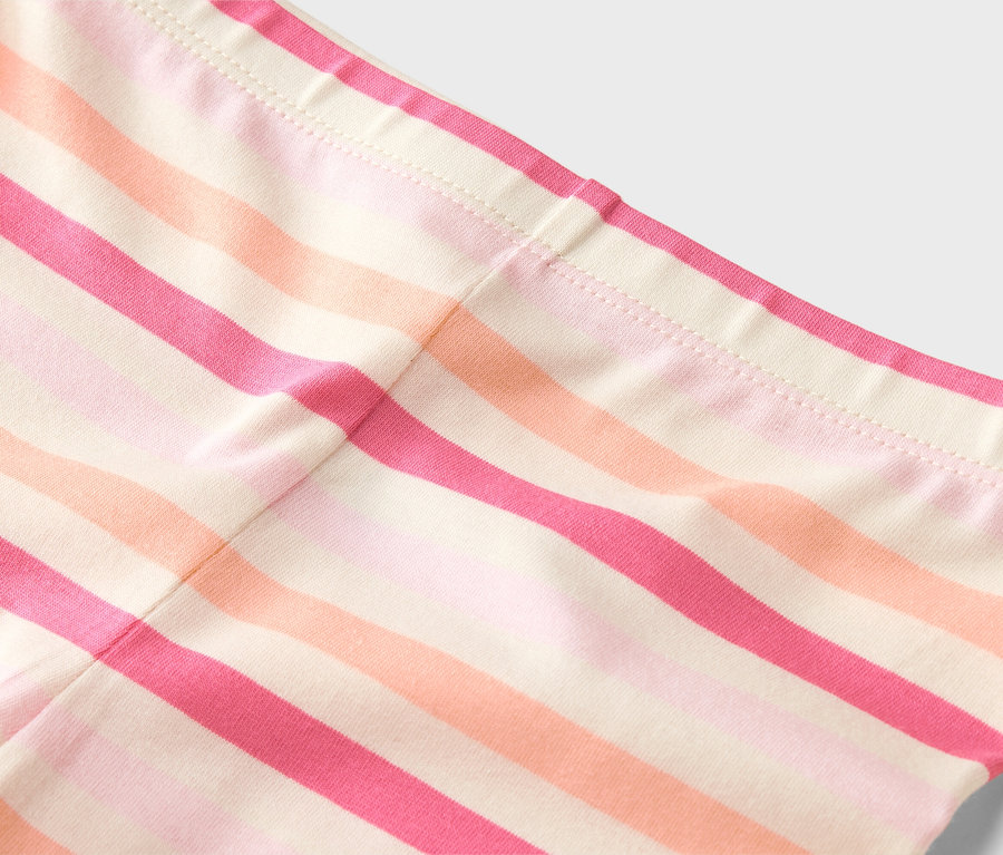 Gros plan sur un legging rayé dans les tons rose, orange et beige.