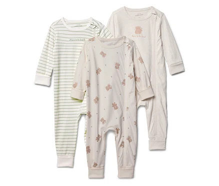 Trois pyjamas pour bébés sont alignés : un rayé, un avec un motif d’ours et un uni avec un appliqué d’ours.