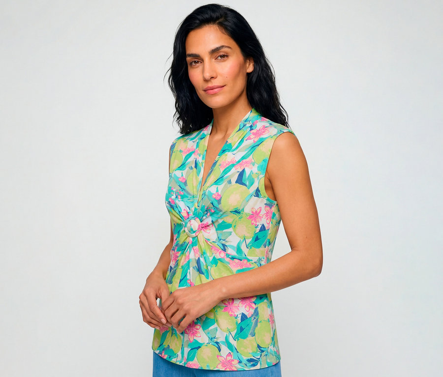 Femme portant un chemisier Olsen sans manches à motif fruité et floral coloré vert, rose et sarcelle, avec un col en V et un anneau décoratif à l'avant.
