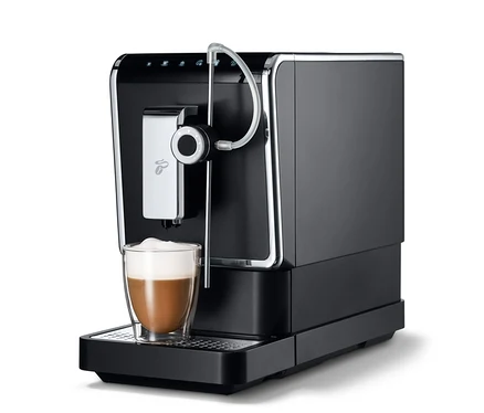 Une machine à café entièrement automatique de Tchibo « Esperto Pro » anthracite avec une tasse de café.