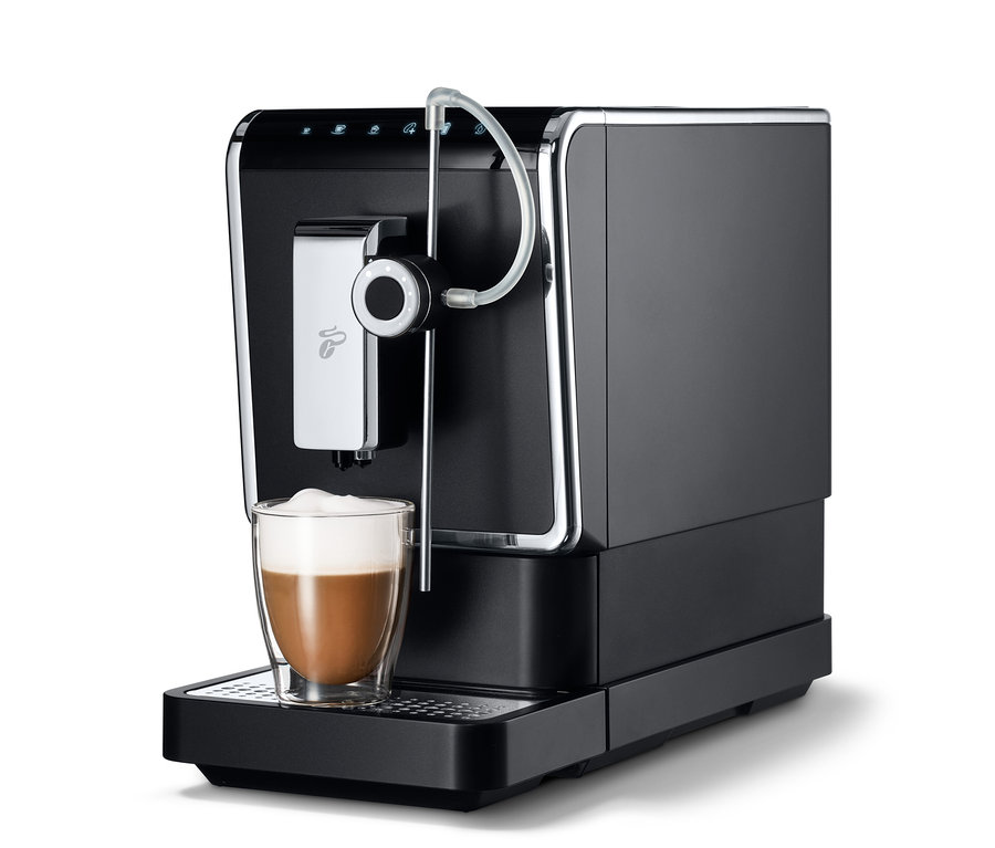 Une machine à café entièrement automatique de Tchibo « Esperto Pro » anthracite avec une tasse de café.