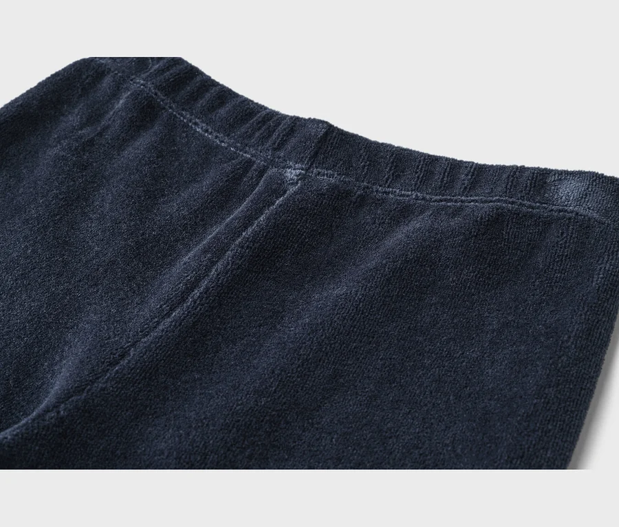 Gros plan sur un tissu éponge bleu foncé avec une taille élastique et des coutures visibles.