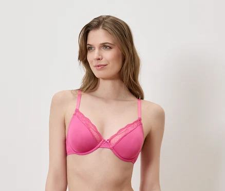 Femme portant un soutien-gorge rose avec de la dentelle.