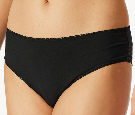 Gros plan d'une femme portant une culotte noire avec des détails en dentelle.